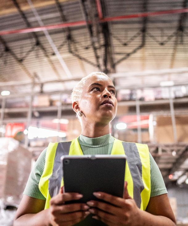 Mid adult woman working using digital tablet in a warehouse